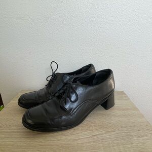 Black leather heeled oxfords with a square toe and lace up front